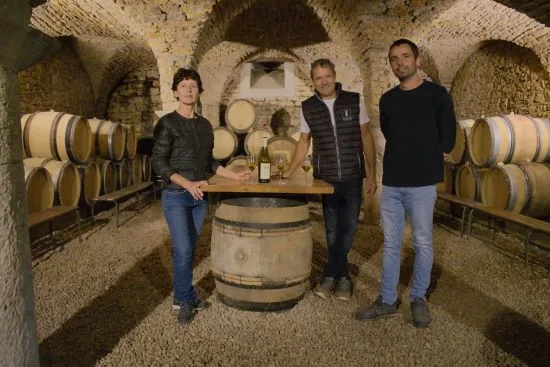 La famille Mouillard dans la cave voûtée, autour d'un fût